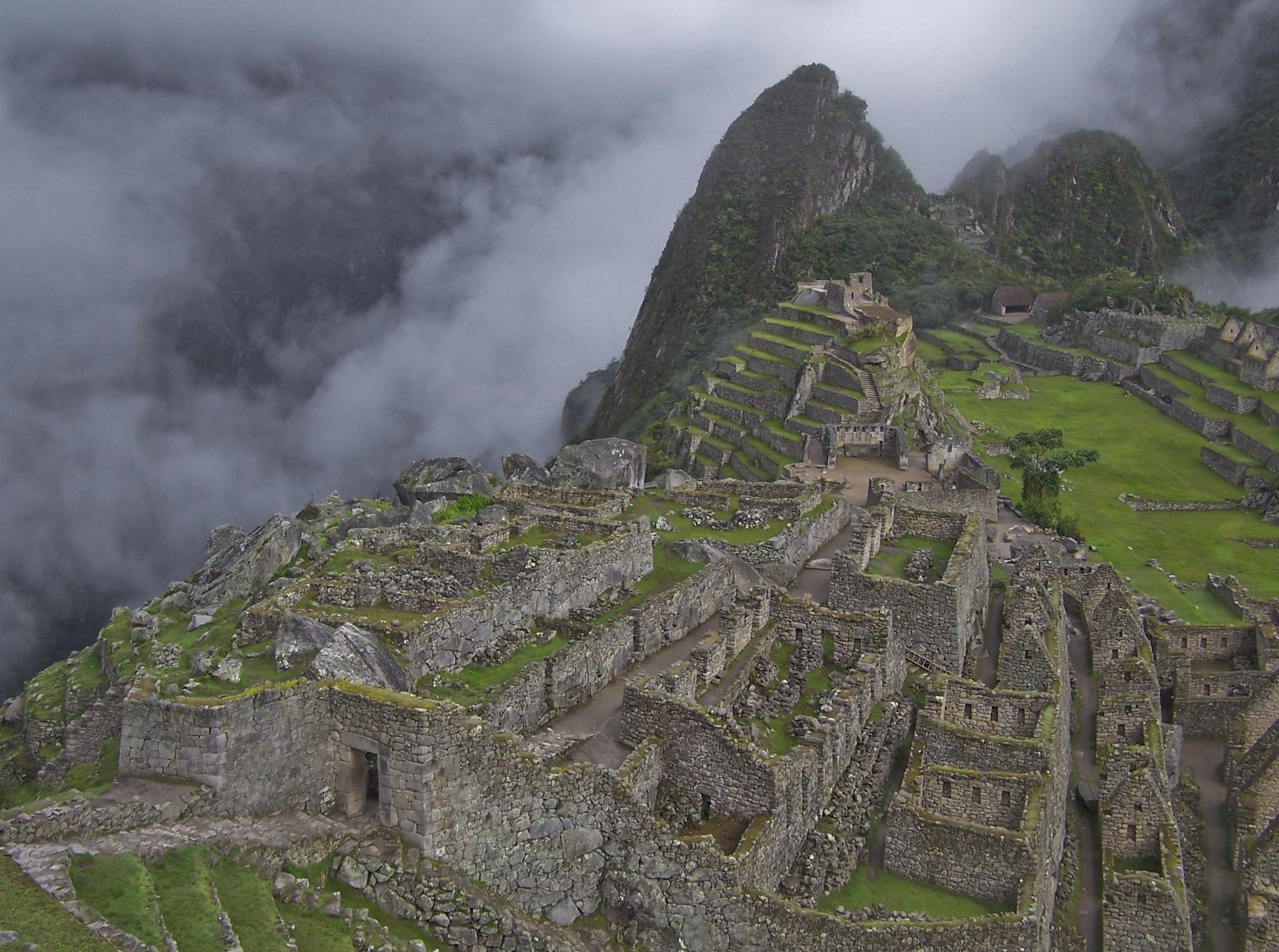 A breathtaking aerial view of Machu Picchu shrouded in mist, highlighting its ancient stone architecture.