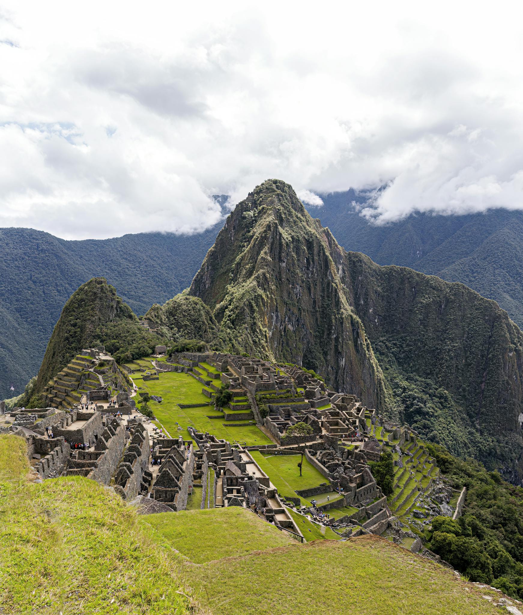 A stunning high-angle shot of Machu Picchu, Peru, showcasing the ancient ruins beneath dramatic clouds.