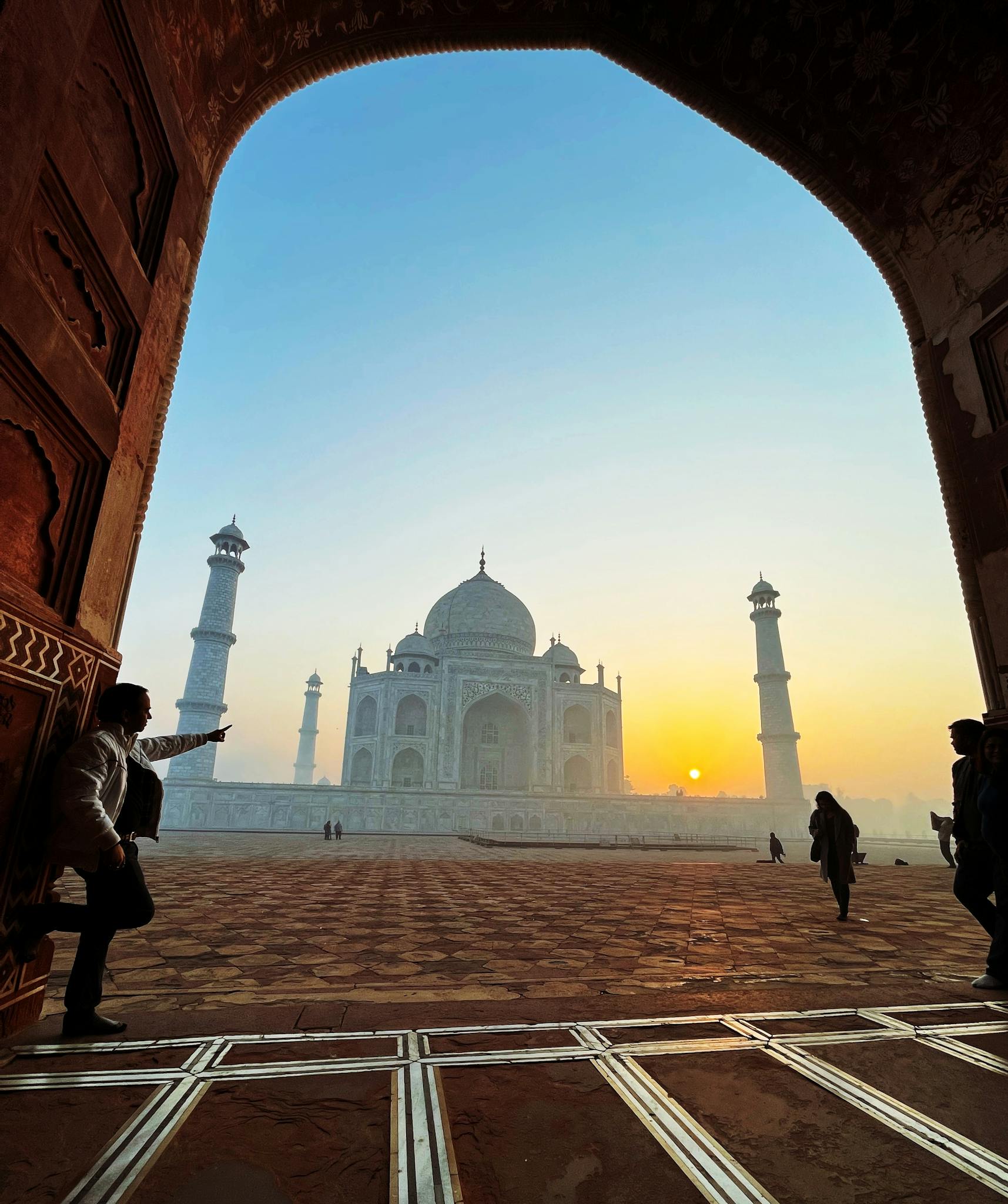Iconic view of the Taj Mahal at sunrise, showcasing its grandeur and beauty.